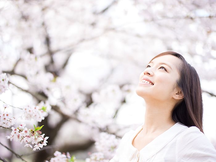 桜の木の下で胸を張る女性